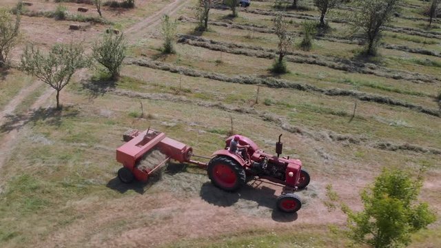 Farmer with tractor make bale of hay