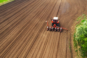 Aerial view of tractor with mounted seeder performing direct seeding