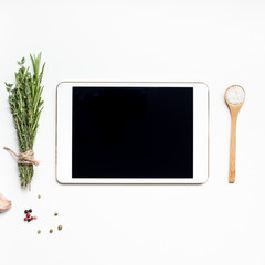 Empty tablet PC with greens herbs and spices