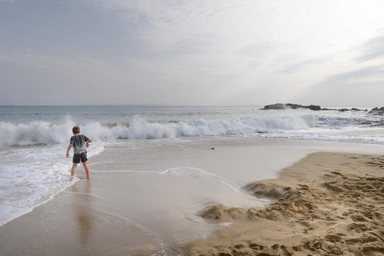 Ni&ntilde;os diviertendose con las olas en  una playa de la Costa Brava, Alt Empord&agrave;, Catalu&ntilde;a, Espa&ntilde;a