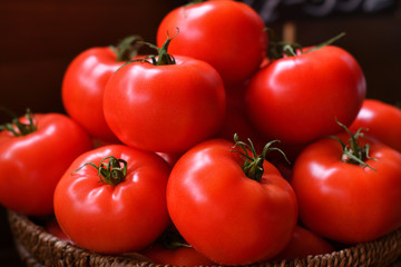 large red tomatoes in a wooden basket