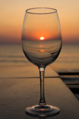 sunrise reflected in a transparent glass at the seashore and ocean