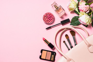 Woman flat lay makup background with cosmetics on pink.