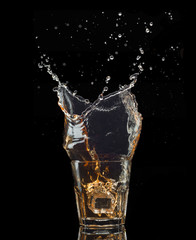 Isolated shot of whiskey with splash on black background
