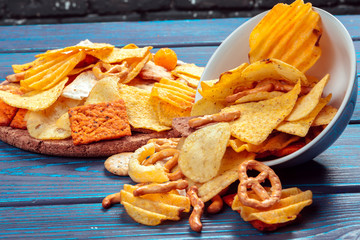 Differnt Types of Junk food, salty-sticks, salty-crackers on wooden table in still-life
