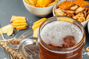 Lager beer and snacks on stone table. Cracker, chips side view