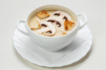 mushroom soup in a plate, decorated with slices of mushrooms and crackers, a vegetarian dish