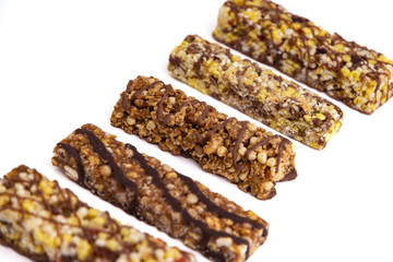 vegan dessert: several cereal bars with raisins and honey, isolated on white, short focus