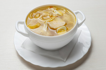 noodle soup, with meat and quail eggs, in a white plate