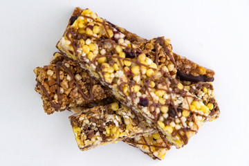 vegan dessert: several cereal bars with raisins and honey, on white, short focus
