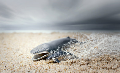 Big whale and baby dolphin tangled in a fishing net . Environmentalism and plastic awareness concept background.