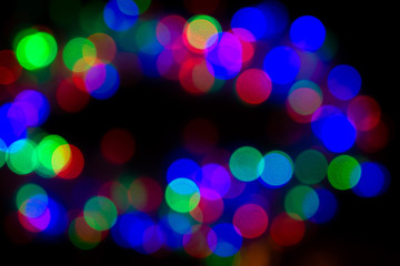 dark background with glowing multicolored lights in defocus, bokeh