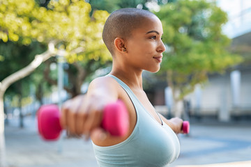 Curvy black woman using dumbbell