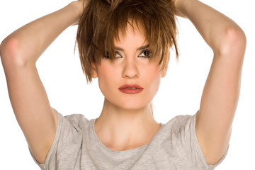 Fototapeta premium Young woman with makeup, holding her hair on white background