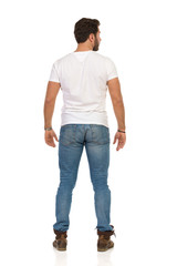 Rear View Of Standing Man In Jeans And WhiteT-shirt
