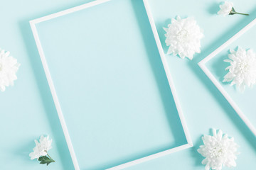 Beautiful flowers composition. Blank frame for text, white flowers on pastel blue background. Valentines Day, Easter, Birthday, Happy Women's Day, Mother's day. Flat lay, top view, copy space