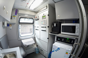 Interior of a service compartment of a wagon (conductor’s): seat, window, electrical stove, refrigerator, washbasin, control panel