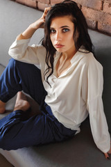 Naklejka premium sexy girl in a blouse and jeans on the couch
