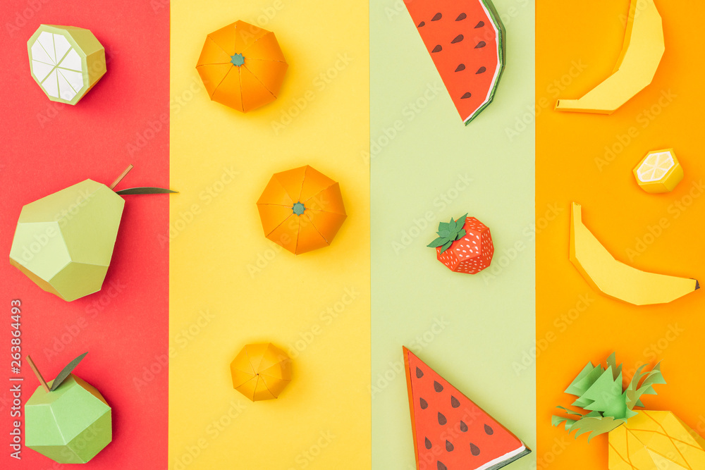 Sticker top view of various handmade origami fruits on multicolored paper stripes