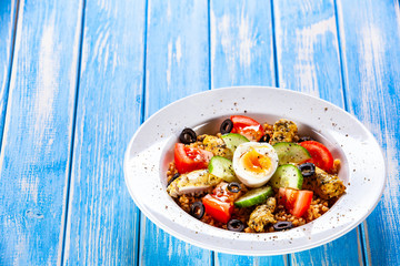 Grilled chicken meat with groats and boiled egg on wooden table