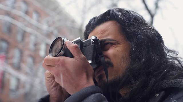 CLOSEUP of a Photographer Taking Photos of Historic Architecture During a Cold Snowy Day