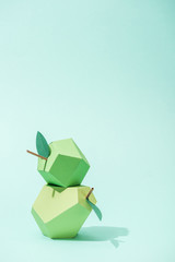 handmade paper pear and apple on turquoise with copy space