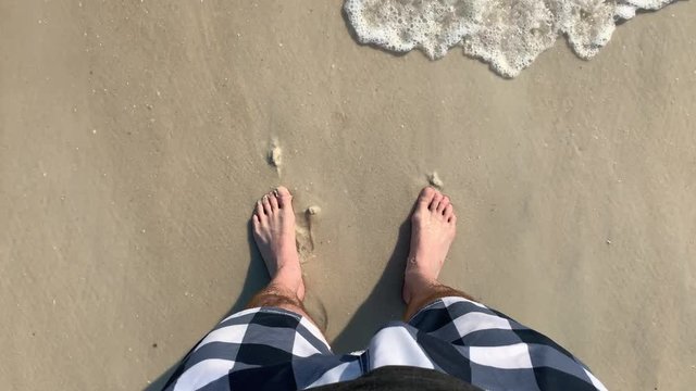 Ocean Waves Wash Over Feet In The Sand On The Beach In Slow Motion First Person POV