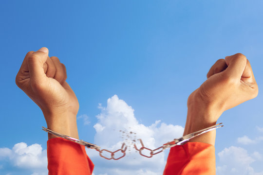 freedom concept. two hands of prisoner with broken handcuff for freedom meaning with blue sky at background
