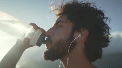 Young man drinking water bottle after workout training - Powered by Adobe
