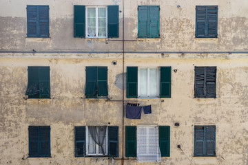 Orange wall with green windows on window Genoa, Italy