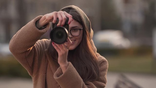 Passionate female photographer clicking portraits vertically with a smile, close up shot