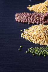 various seeds on a wooden black background