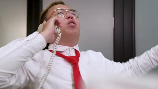 A man speaking on the phone then dace in a funny way mocking the person that are on the phone.