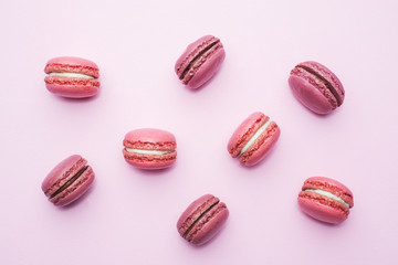 Pink dessert macaron or macaroon on pink background top view. Flat lay.