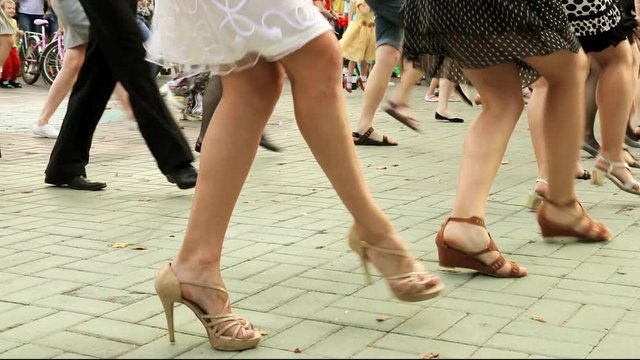 Girls in elegant dresses dancing dance Charleston in the Park. feet close-up
