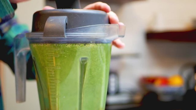 A high powered blender is spinning, turning various fruits, vegetables, and supplements into a delicious and nutritious green smoothie! Perfect cleanse made in your own kitchen!