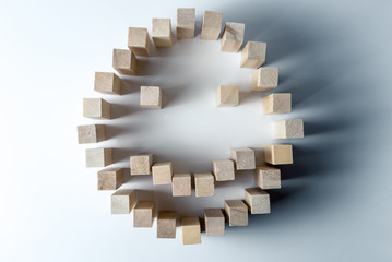 a large smiley made of wooden cubes, as a symbol of happiness, success and accomplished task, on an uneven white background. Horizontal frame
