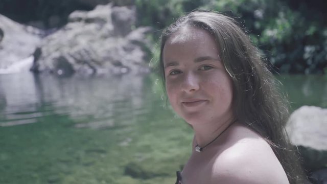 SLOW MOTION: girl messing with her hair next to Mango waterfall in Adjuntas, Puerto Rico.