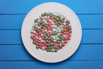 White plate with color preparations (vitamins, dyes, flavor enhancers, nutritional supplements,...