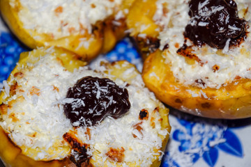 Apples baked with cottage cheese and decorated with chocolate and coconut chips.