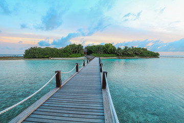 Amazing island in the Maldives ,wooden bridge and  beautiful  turquoise waters with  blue sky  background for holiday vacation .