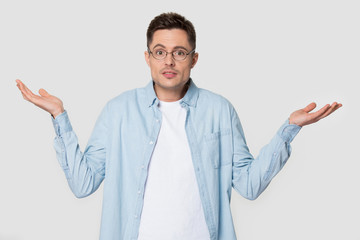 Puzzled Caucasian man in glasses shrug shoulders isolated on background