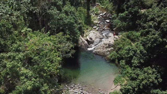 AERIAL: pushing through a forestry to reveal the magical scenery of Mango Waterfall in Adjuntas, Puerto Rico.