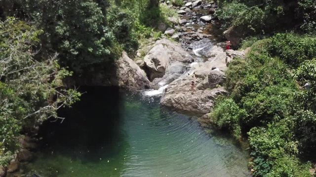 AERIAL: pulling through some forestry away from the magical scenery of Mango Waterfall in Adjuntas, Puerto Rico.