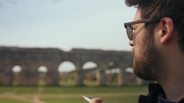 Man smoking a cigarette in the park.