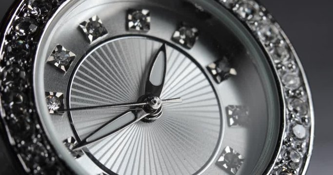 Close-up shot of a beautiful, diamond-studded women's watch at 12:45.