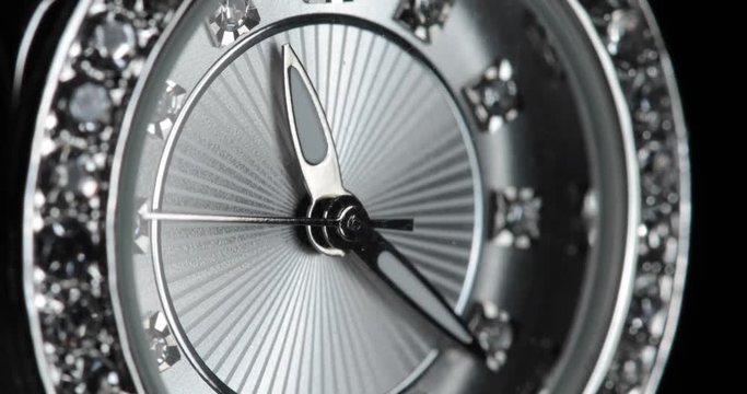 Angled, macro shot of a diamond-studded, silver women's watch.