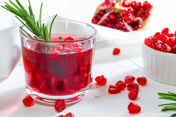 Summer drink with pomegranate and rosemary. White background.