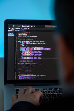Programmer working on laptop computer in office