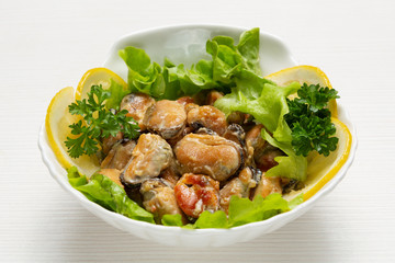 dish of mussels in a delicate sauce, with dorblu cheese, in a deep plate, decorated with lemon and greens